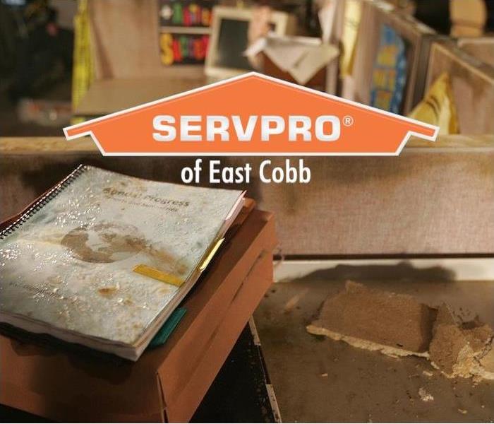  a workspace and cubicle showing signs of water damage with SERVPRO of East Cobb logo