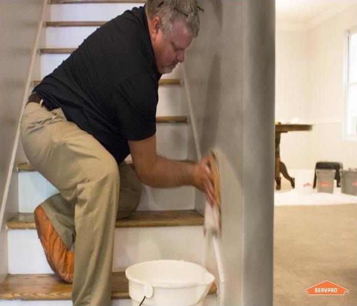technician cleaning smoke and soot residue from stairs
